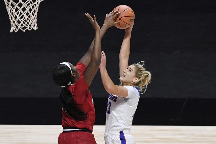Louisville's Elizabeth Dixon, left, stops a shot-attempt by DePaul's Dee Bekelja