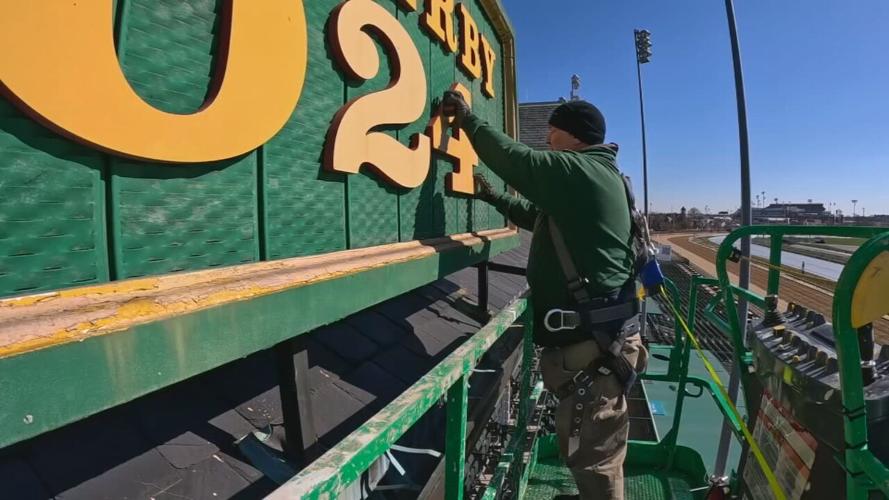 Crews change the sign at Churchill Downs from "2023" to "2024"