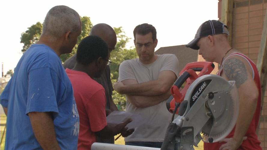 Men standing around saw at Green Wall Build in Park DuValle