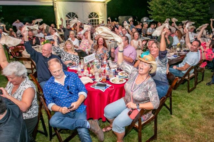 People eat dinner at Boots, Badges and Bids.jpg
