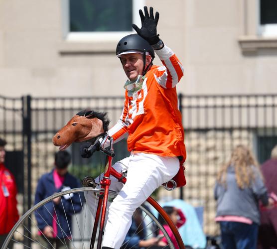 Bicycler waves to crowd at parade.JPG
