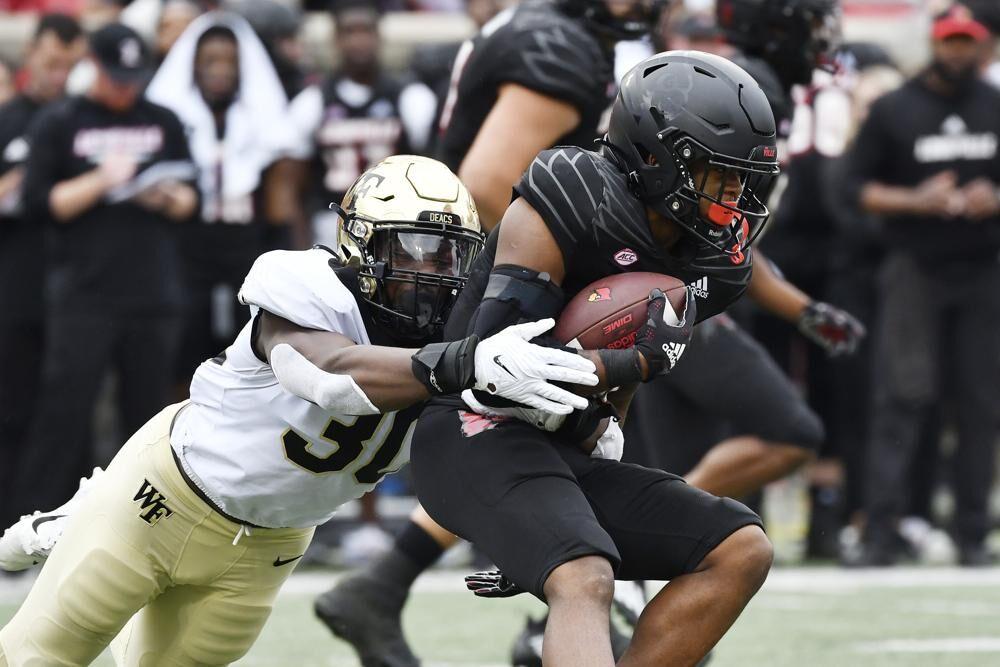Louisville running back Trevion Cooley is grabbed by Wake Forest