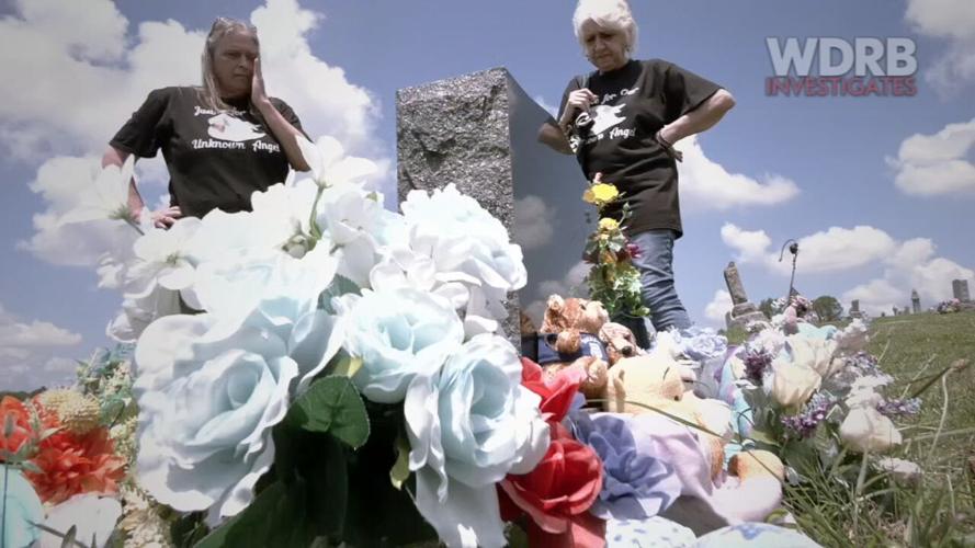 Yvonne Casey and Janet Irk stand beside the grave of an unidentified boy, believed to be 5 years old, found dead in a suitcase in Washington County, Indiana