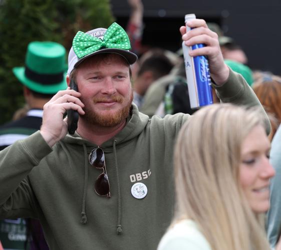 Man holds up beer at parade