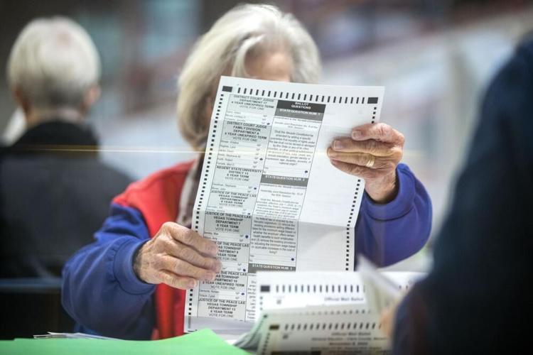 An election worker inspects a mail-in ballot.jpeg