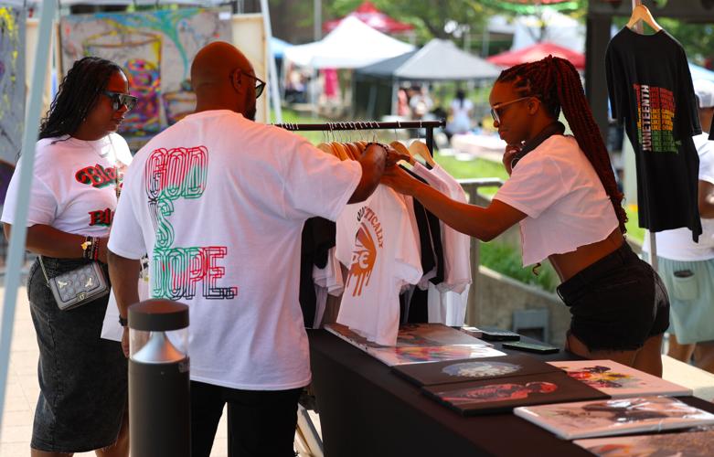 Vendor passes out shirt at Juneteenth Festival.JPG