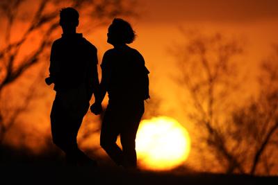 Couple walks at sunset - AP