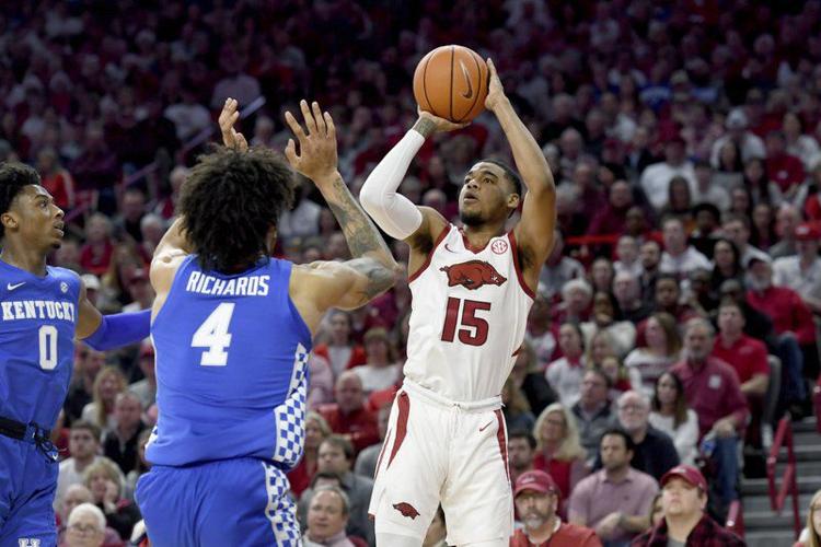 Arkansas guard Mason Jones (15) pulls up to shoot over Kentucky defenders