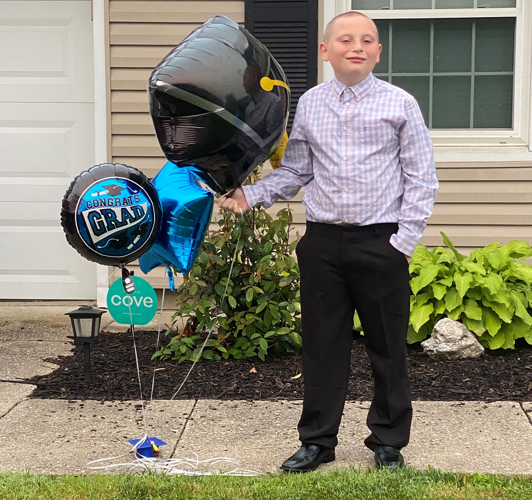 Noah Mattingly with graduation balloons