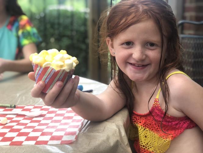 Girl decorates cupcake at Let's Get Crafty! event