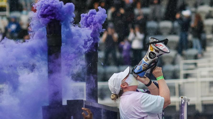 A Racing Louisville FC supporter cheers through a megaphone