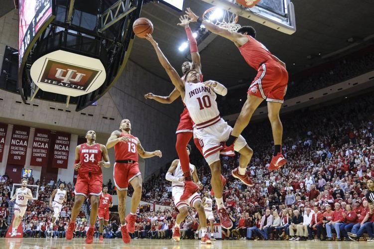 Indiana guard Rob Phinisee, center, shoots between Ohio State defenders Andre Wesson