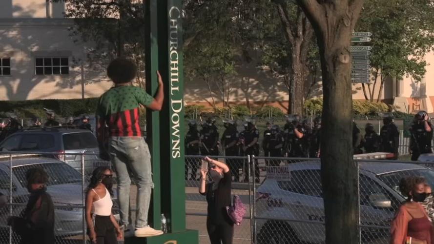 Protester on Churchill Downs sign during Derby