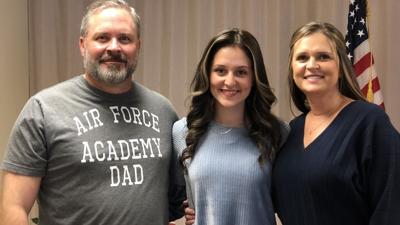 Morgan Quire (center), with parents, Richard Quire (left) and Kimberly Quire (right)