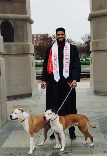 Trey Moses poses for a graduation photo with his dogs