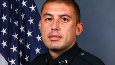 Pablo Cano in LMPD uniform next to flag