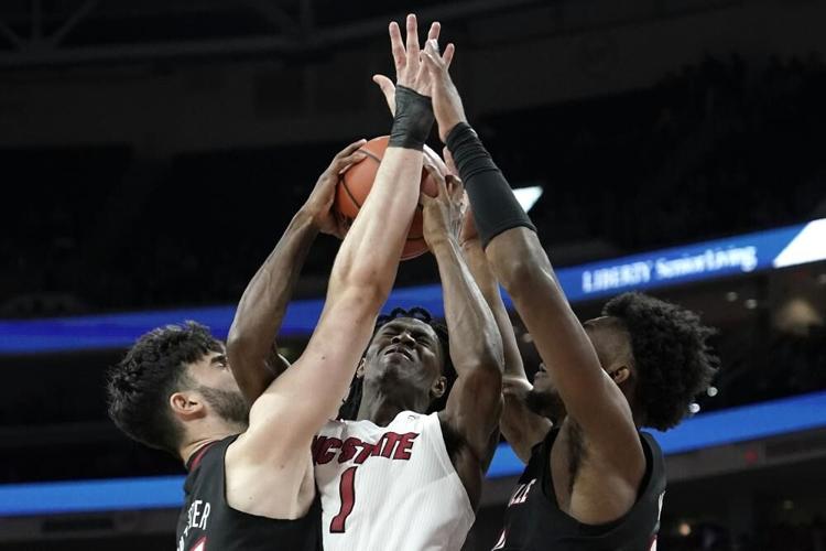 North Carolina State guard Dereon Seabron drives between Louisville center Gabe Wiznitzer.jpeg