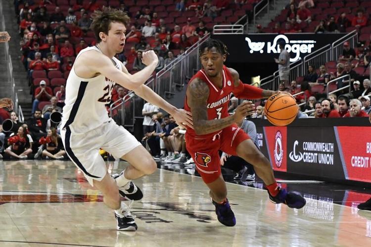 Louisville guard El Ellis attempts to drive past Virginia guard Kody Stattmann.jpeg