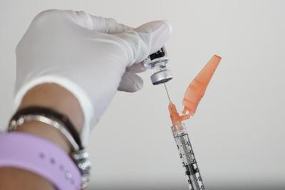 Nurse loads a syringe of COVID19 vaccine.jpeg