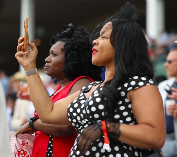Two women record on their phones a race.JPG