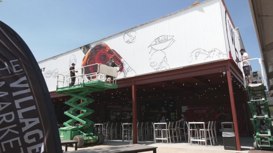 Artist works on a Derby mural in Louisville's Paristown arts district