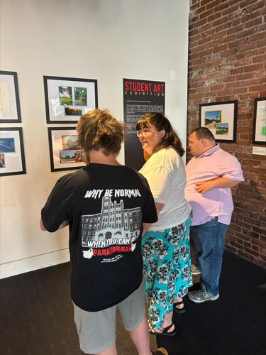 Artists review a Frazier History Museum exhibit showcasing work by artists with Down Syndrome