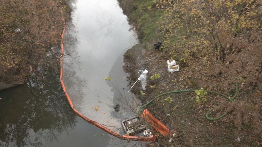 Crews remove oil film and sludge