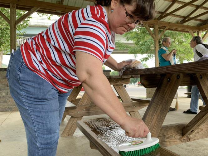 Woman cleaning bench after 'Kookout'