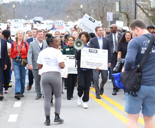 Signs and students walk at march.JPG