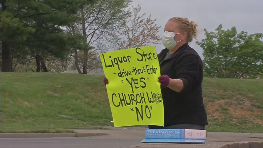 Woman holding sign outside On Fire Christian Church
