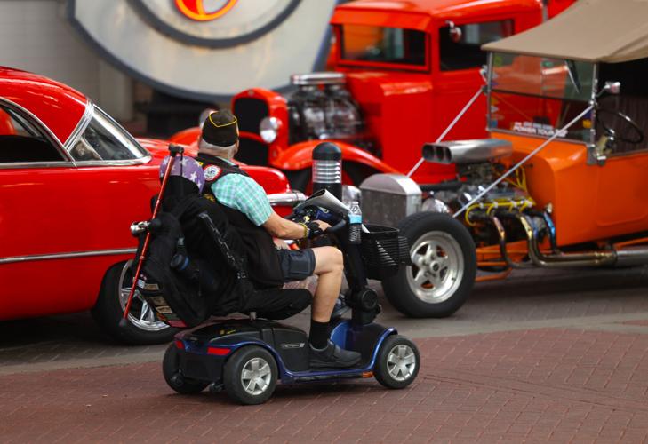 A man rolls past Street Rods.JPG