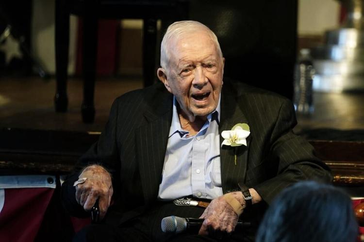 Former President Jimmy Carter reacts as his wife Rosalynn Carter speaks during a reception.jpeg