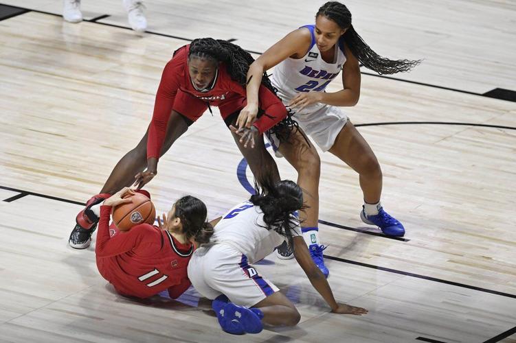 Louisville's Norika Konno, bottom left, and Olivia Cochran, top left, keep the ball from DePaul's Maya Stovall