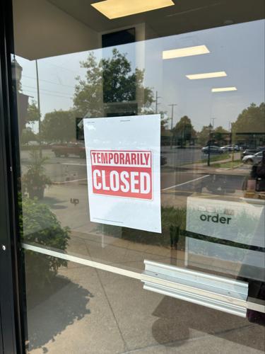 A sign on the door of a store at The Paddock Shoppes during escaped inmate search on May 18, 2023