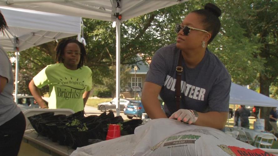 Woman scooping dirt at Green Wall Build in Park DuValle