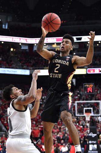 Florida State guard Anthony Polite (2) passes over the defense of Louisville guard Lamarr Kimble