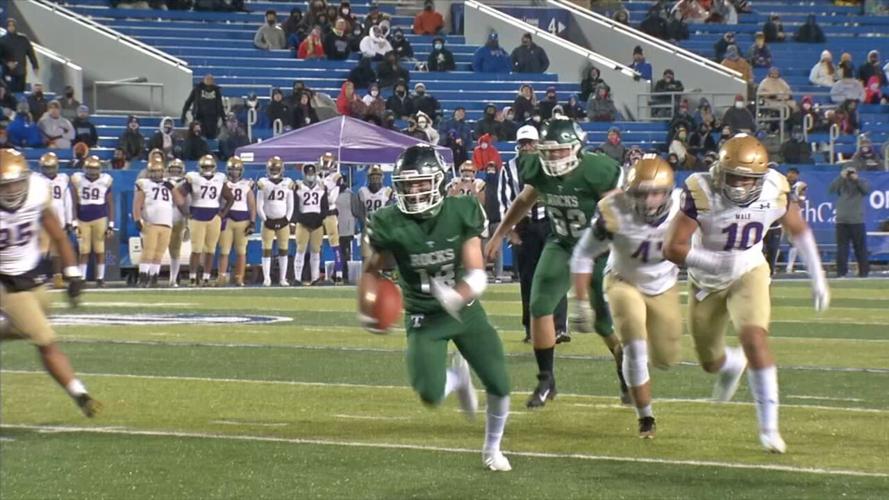 Trinity running back Brad West, center, runs against Male
