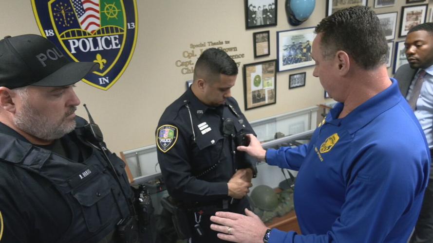 A New Albany police officer putting on a body camera