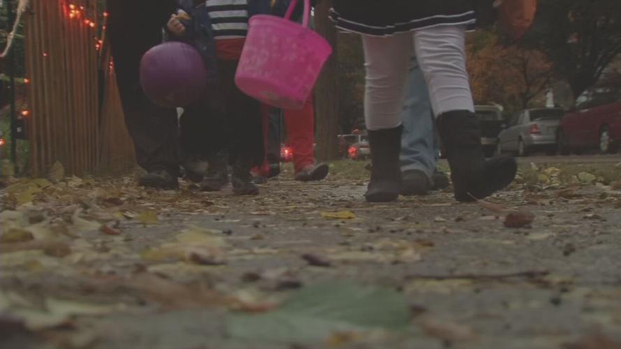 Trick-or-treaters roam sidewalk on Halloween