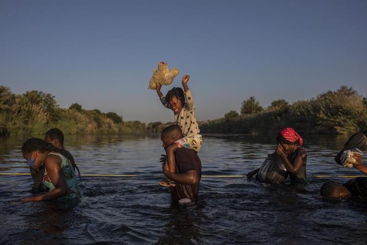 Migrants wade across Rio Grande river