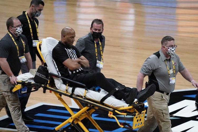 Referee Bert Smith is taken off the court on a stretcher after collapsing during the first half of an Elite 8 game