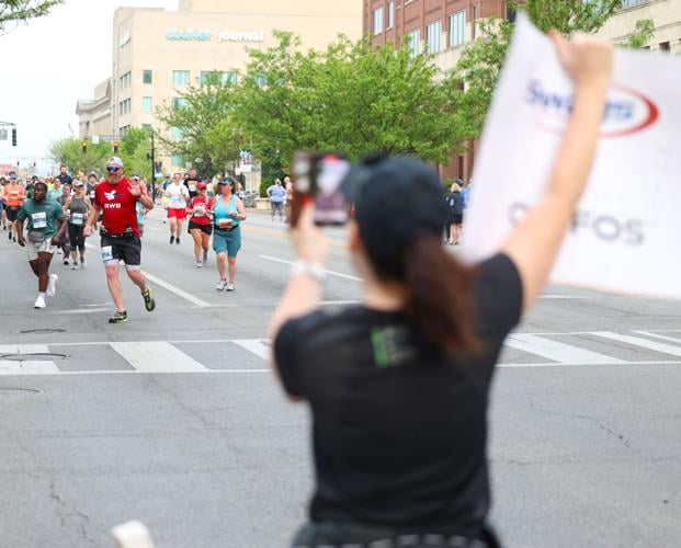 WOman holds sign of support, phone.JPG