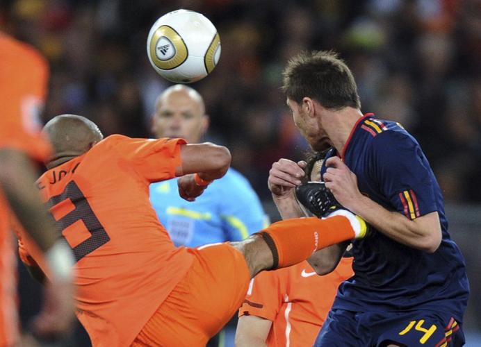 Netherlands' Nigel de Jong, left, fouls Spain's Xabi Alonso