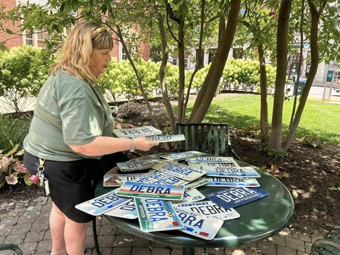 Debra Humphrey goes through a stack of personalized license plates she's kept for years