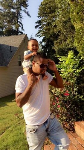 Tiwuan Johnson carries son on shoulders