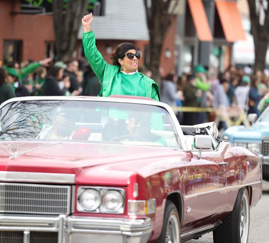 Woman in red car waves to crowd