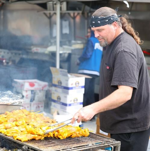 Man prepares food on grill.JPG