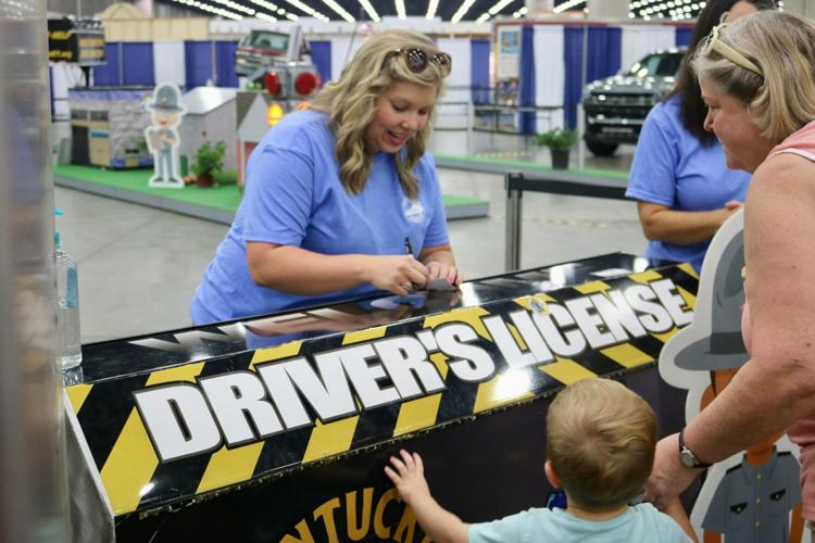 KSP volunteer helps set up little boy with fake driver's license.jpg