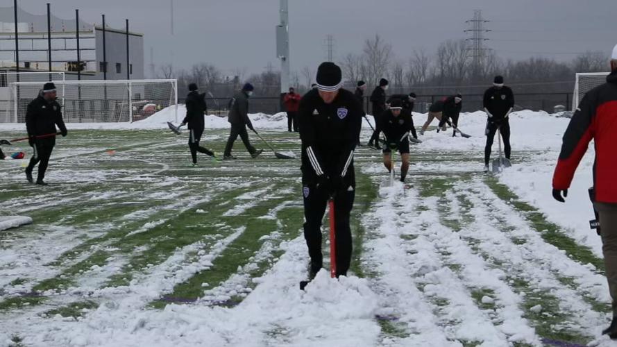 LouCity players shovel snow before practicing.jpeg