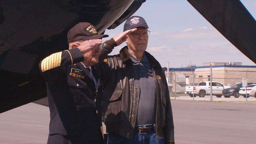 WWII veterans honored with flight give salute next to aircraft